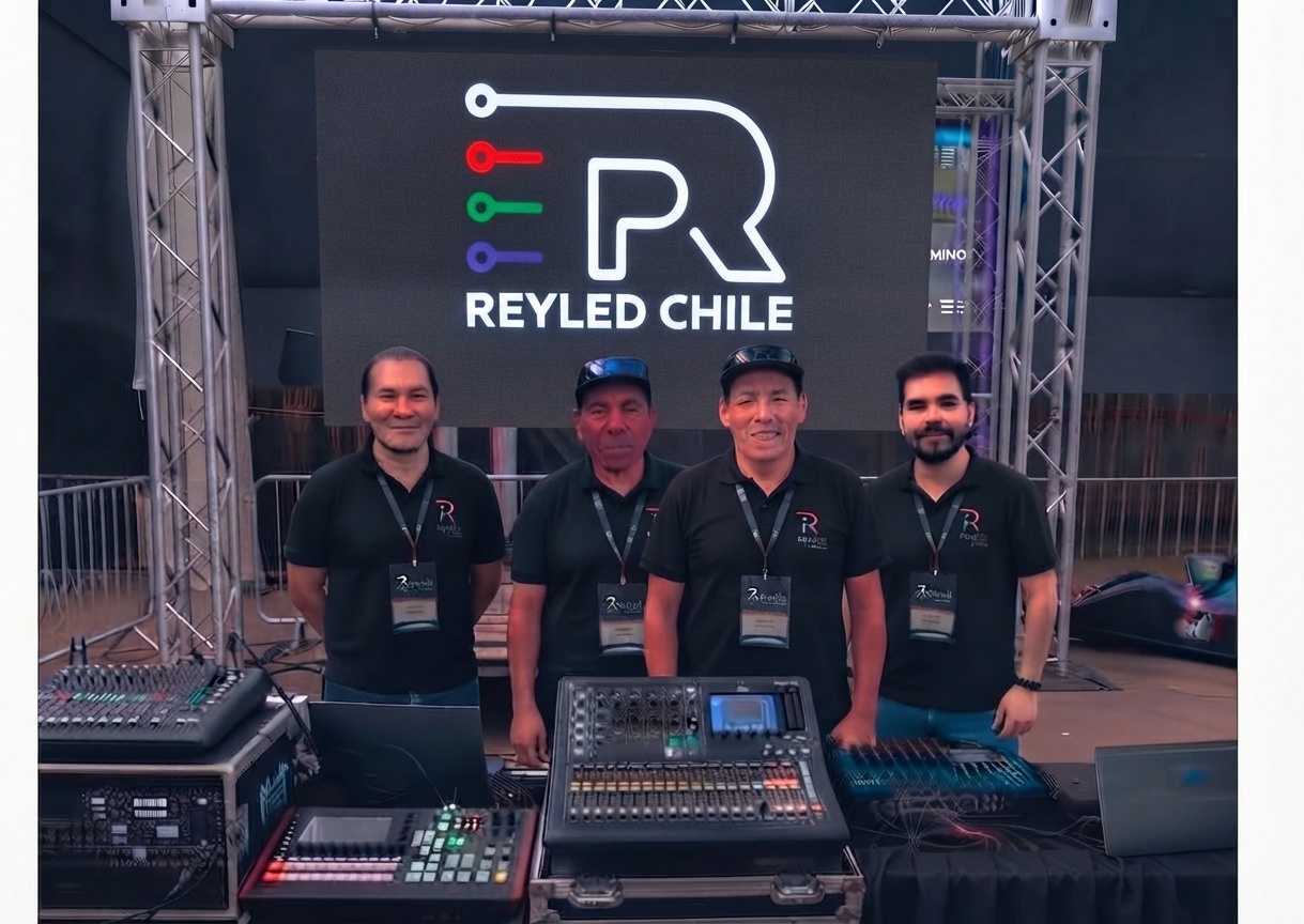 Cuatro integrantes del equipo REYLED Chile junto a consolas y equipos audiovisuales
